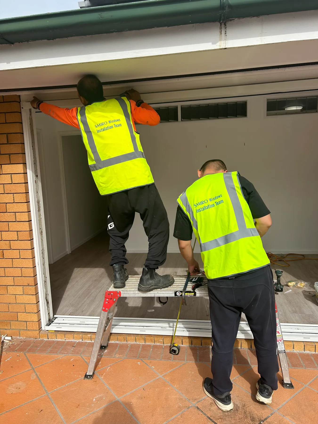 SMIRO installation team fitting a new aluminium sliding door frame in Kenmore Queensland